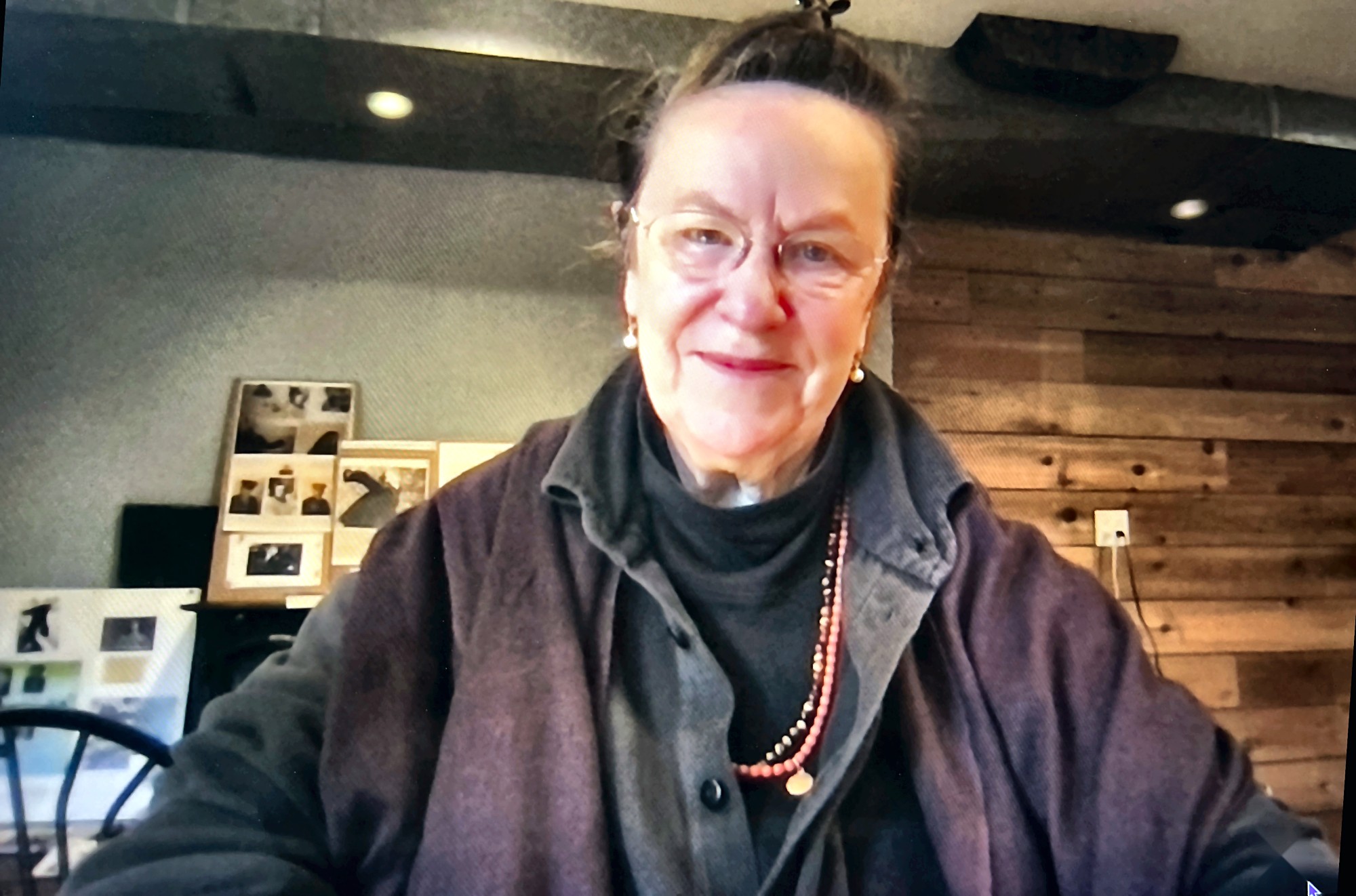 Eleanor Claire Johnson in her studio, with archival photographs from the Emmatroupe Theatre Laboratory behind her.