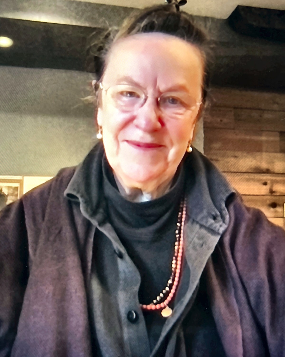 Eleanor Claire Johnson in her studio, with archival photographs from the Emmatroupe Theatre Laboratory behind her.