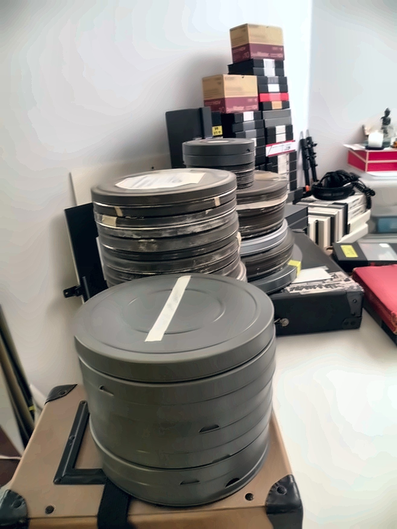 A stack of film cans holding raw footage from the Emmatroupe archive.